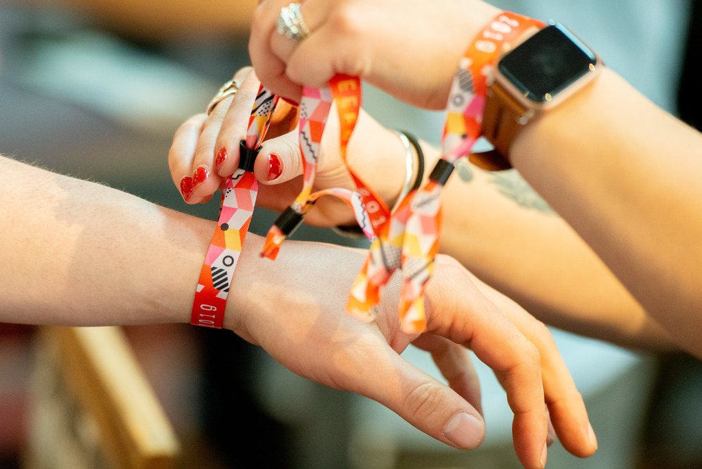 Festival wristbands being fastened at a music event entrance.